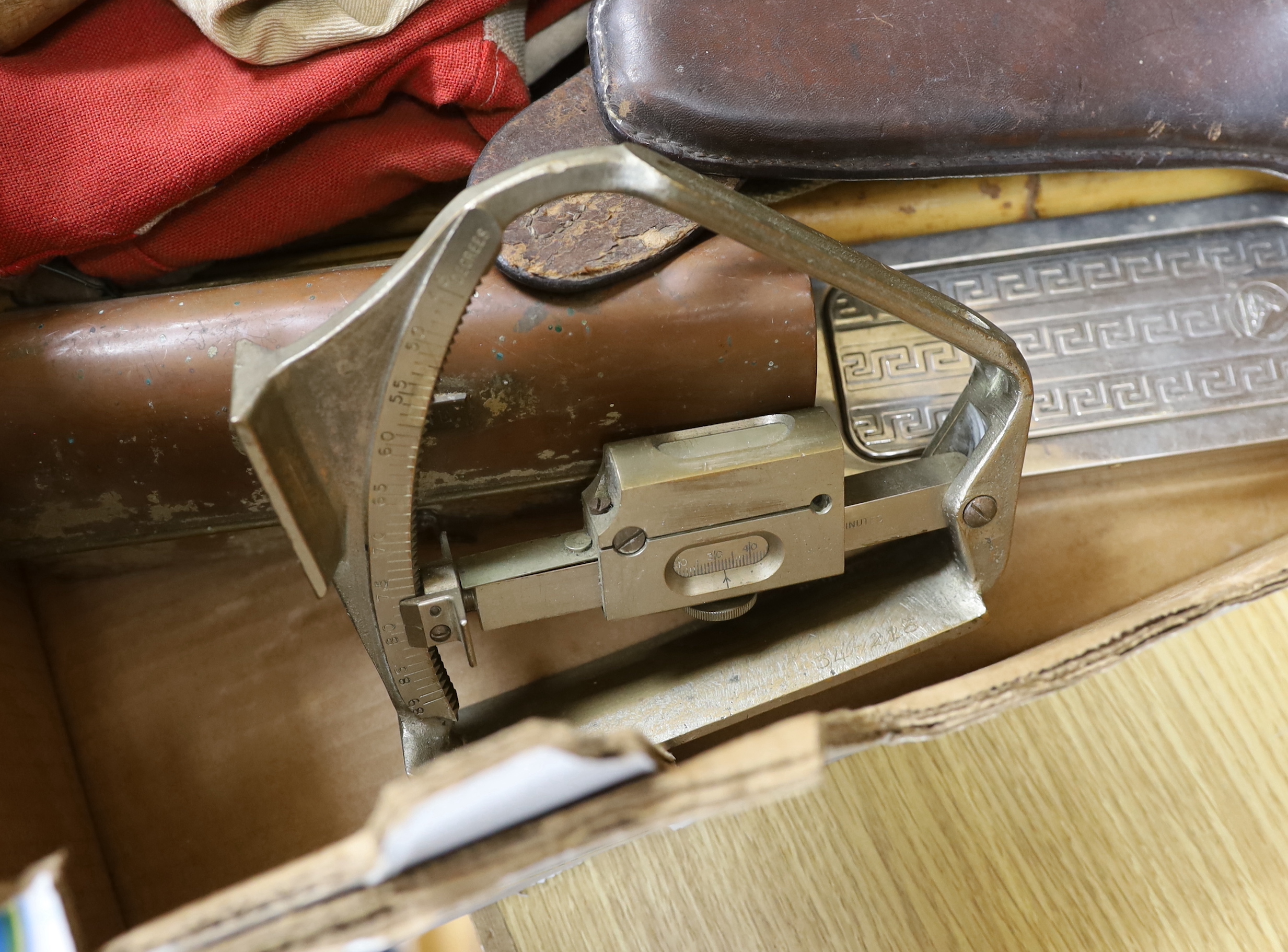 A collection of militaria including a union flag, gunners sight, camouflage webbing, a water bottle, an axe, a bosun’s whistle, and other items